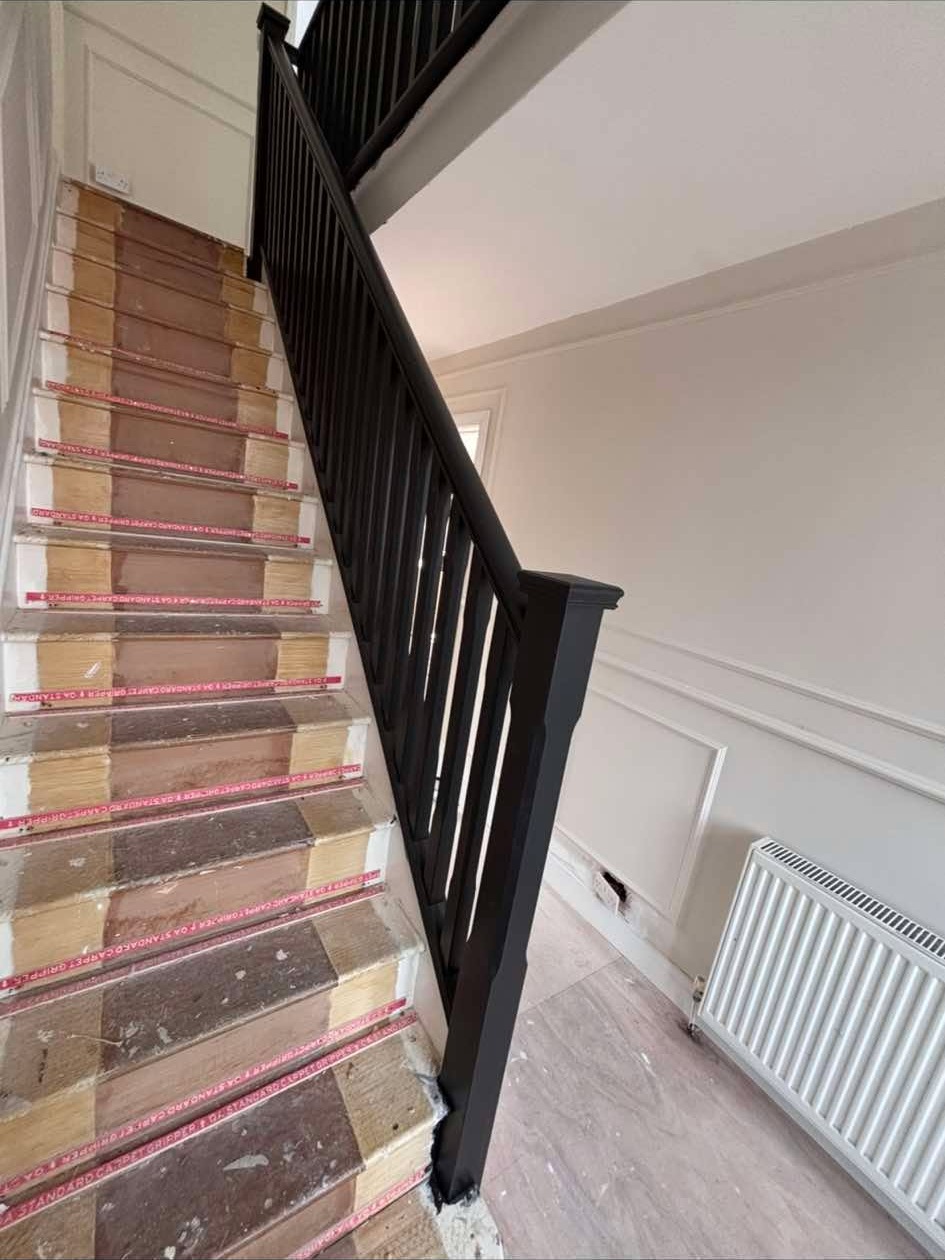 Black painted staircase and white panelled hallway